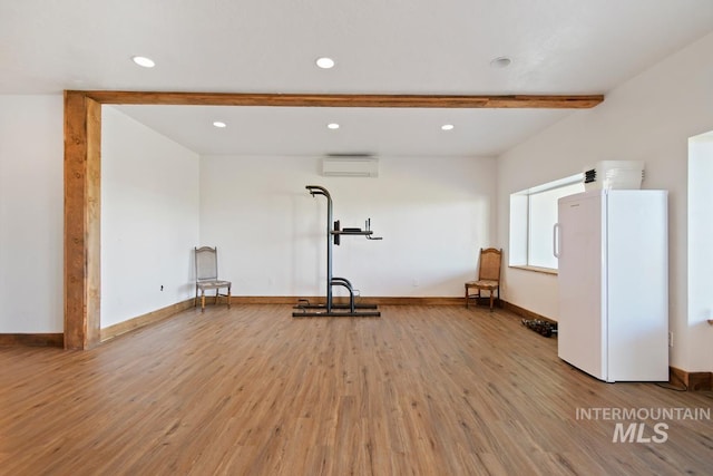 workout room with hardwood / wood-style flooring and a wall unit AC