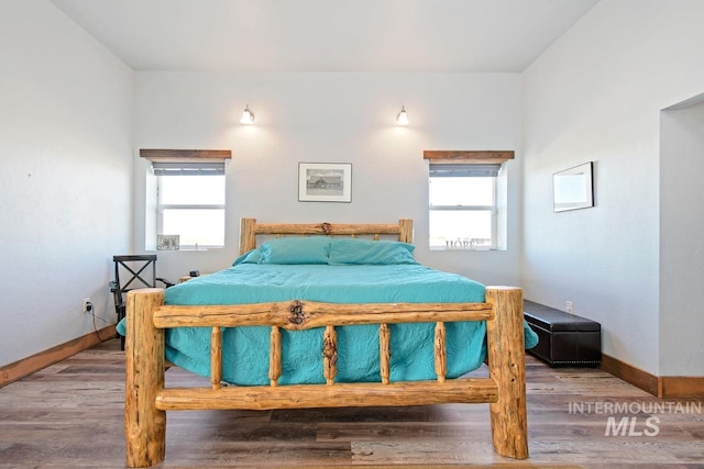 bedroom featuring wood-type flooring and multiple windows