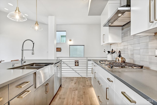 6420 W Glencrest Ln, Boise, ID 83714 - kitchen with stainless steel appliances, a sink, light wood-type flooring, wall chimney exhaust hood, and decorative backsplash