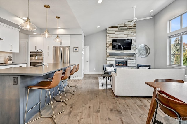 6420 W Glencrest Ln, Boise, ID 83714 - kitchen with vaulted ceiling, a ceiling fan, light wood-style floors, appliances with stainless steel finishes, and open floor plan