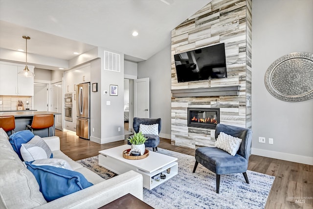 6420 W Glencrest Ln, Boise, ID 83714 - living room with vaulted ceiling, baseboards, visible vents, wood finished floors, and a tile fireplace