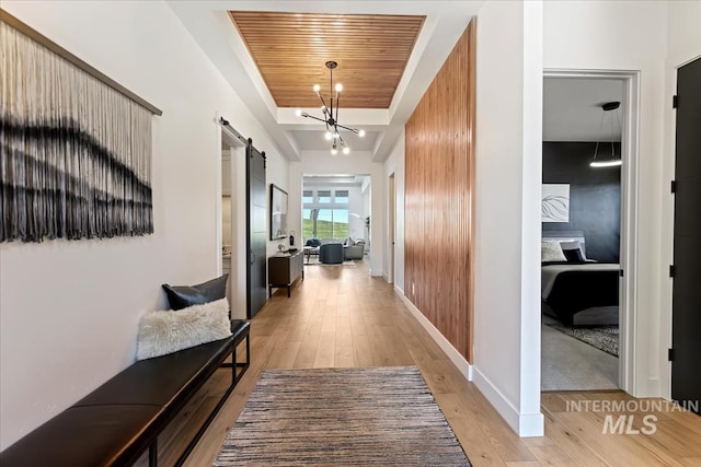 1093 N Morehouse Ave, Eagle, ID 83616 - corridor with baseboards, a barn door, light wood finished floors, and wood ceiling