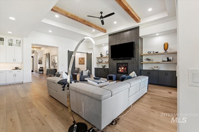 1093 N Morehouse Ave, Eagle, ID 83616 - living area with a ceiling fan, light wood-style flooring, beam ceiling, and a tile fireplace