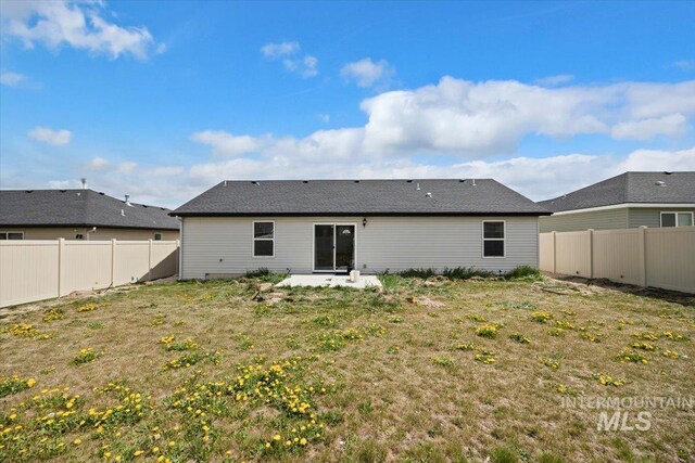 back of house with a fenced backyard, a patio, and a lawn