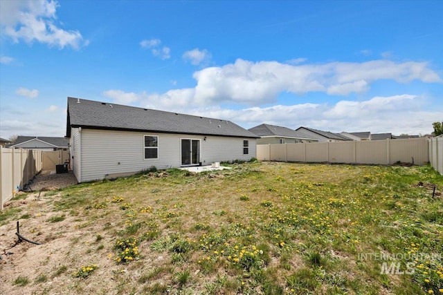 rear view of house with central AC unit and a fenced backyard