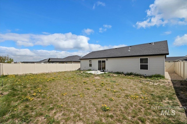 back of house featuring a fenced backyard, a patio area, and a yard