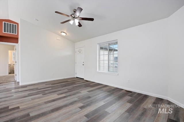 empty room with visible vents, ceiling fan, lofted ceiling, and wood finished floors