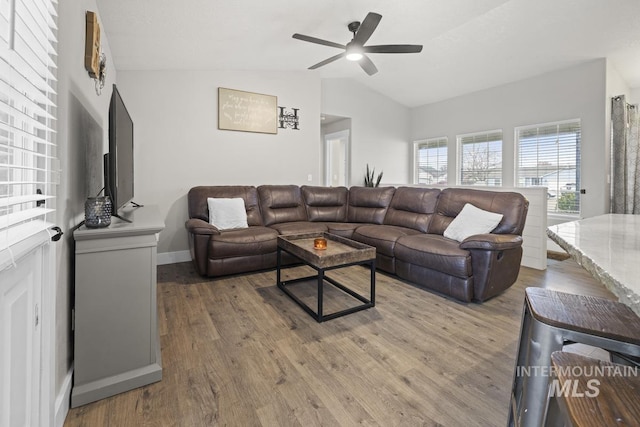 living room featuring ceiling fan, wood-type flooring, and vaulted ceiling