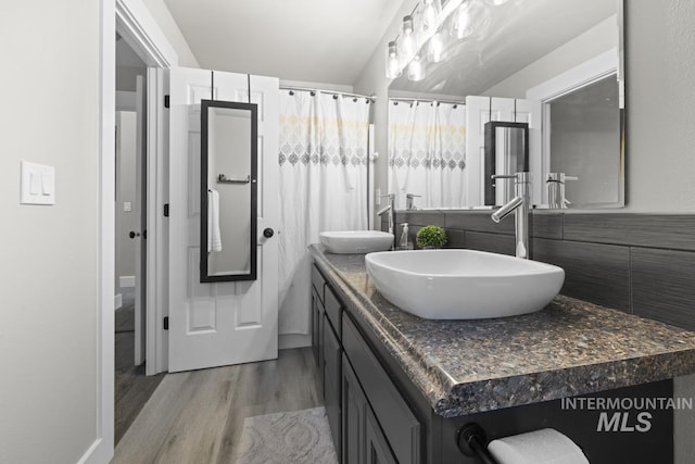 bathroom with vanity, wood-type flooring, and tile walls