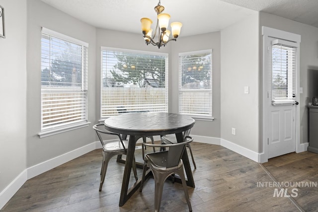 dining space featuring plenty of natural light, dark hardwood / wood-style flooring, and a chandelier