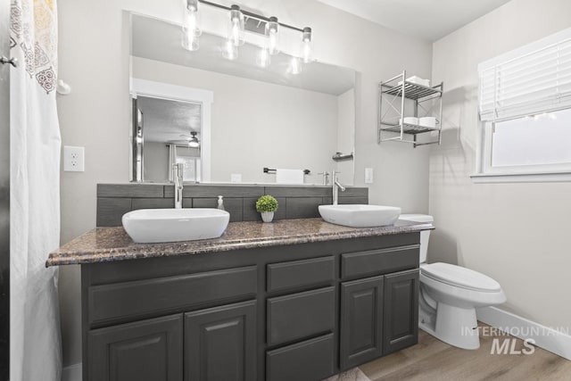 bathroom featuring ceiling fan, hardwood / wood-style floors, plenty of natural light, toilet, and vanity