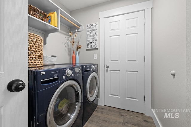 clothes washing area featuring washer and clothes dryer and dark hardwood / wood-style flooring