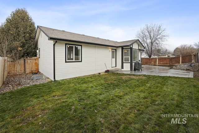 back of house with a yard and a patio