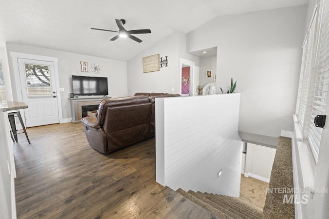 living room with hardwood / wood-style floors, ceiling fan, and lofted ceiling