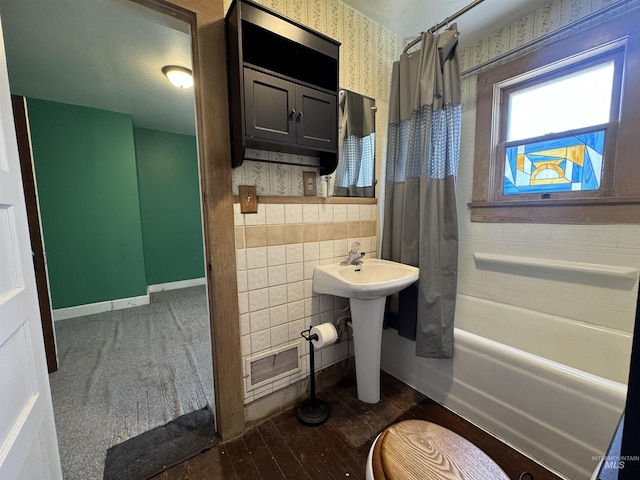 104 E B St, Shoshone, ID 83352 - bathroom with wallpapered walls, shower / tub combo, tile walls, wood finished floors, and a sink