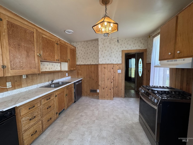 104 E B St, Shoshone, ID 83352 - kitchen featuring appliances with stainless steel finishes, under cabinet range hood, a sink, wainscoting, and light countertops