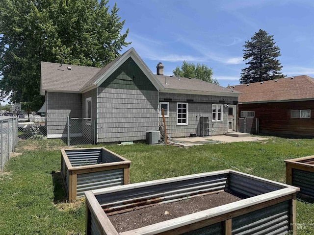 104 E B St, Shoshone, ID 83352 - rear view of house with a vegetable garden, a chimney, a patio, roof with shingles, and central air condition unit