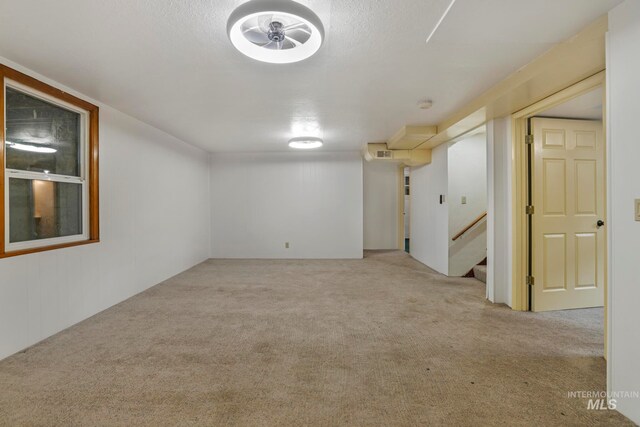 unfurnished room featuring light colored carpet and a textured ceiling