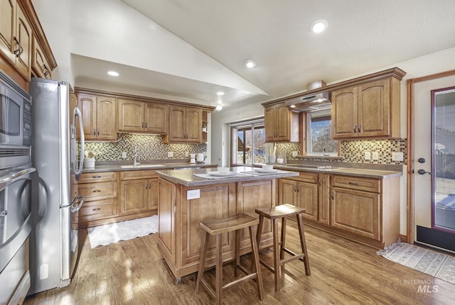 kitchen featuring lofted ceiling, sink, a kitchen bar, a center island, and stainless steel appliances