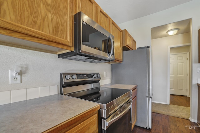 1460 N Pointe Dr, Twin Falls, ID 83301 - kitchen with appliances with stainless steel finishes, brown cabinets, dark wood-type flooring, and light countertops