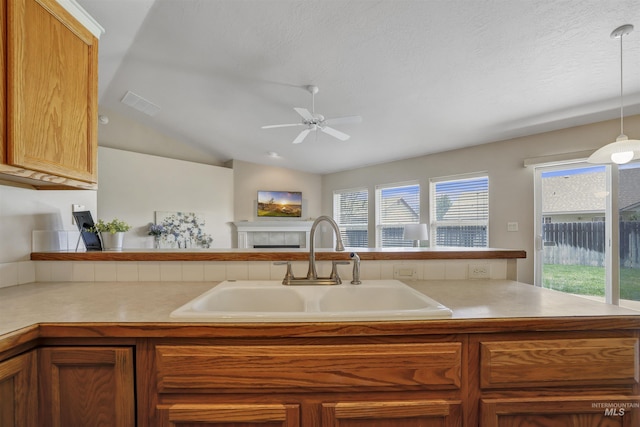 1460 N Pointe Dr, Twin Falls, ID 83301 - kitchen featuring a ceiling fan, light countertops, a tiled fireplace, plenty of natural light, and lofted ceiling