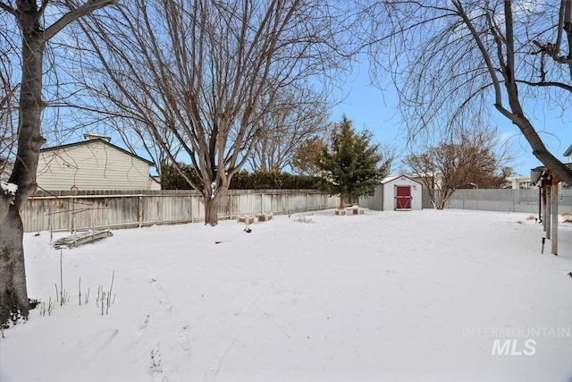 yard layered in snow with a shed