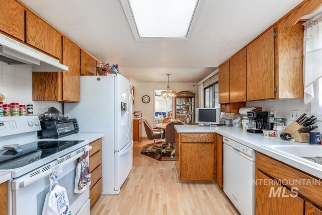 392 S Sun Burst Way, Boise, ID 83709 - kitchen featuring white appliances, light wood finished floors, brown cabinets, and a chandelier