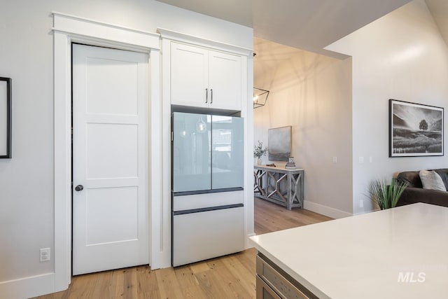 kitchen with light hardwood / wood-style floors and white cabinets