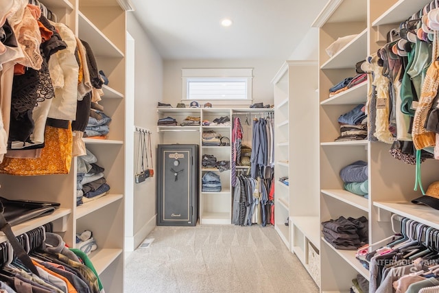 walk in closet with light colored carpet