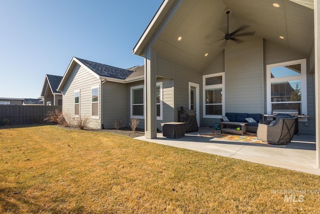 rear view of house with an outdoor living space, a patio area, ceiling fan, and a lawn