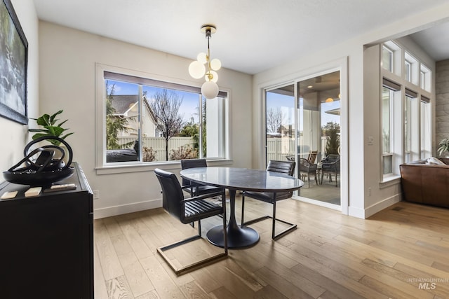 dining space with light wood finished floors and baseboards