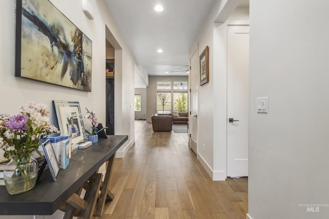 hallway with baseboards, hardwood / wood-style floors, and recessed lighting