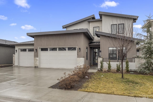 view of front of home featuring a garage, a front yard, concrete driveway, and stone siding