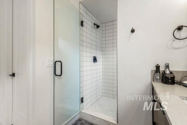 full bath with a shower stall and vanity