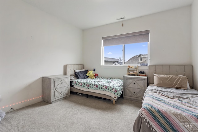 bedroom featuring visible vents and light colored carpet