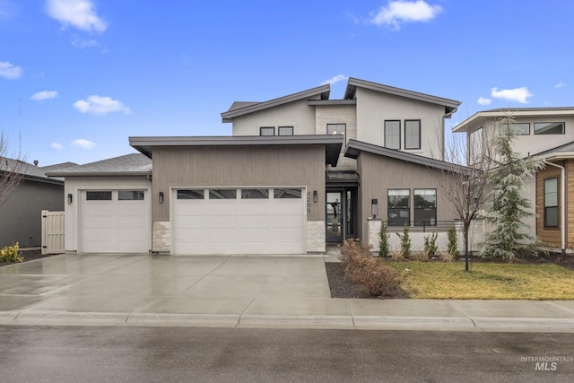 view of front of property with driveway, stone siding, and an attached garage