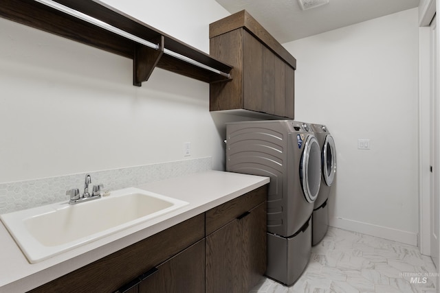 laundry room with cabinet space, baseboards, marble finish floor, separate washer and dryer, and a sink