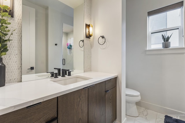 full bath featuring marble finish floor, toilet, vanity, a shower stall, and baseboards