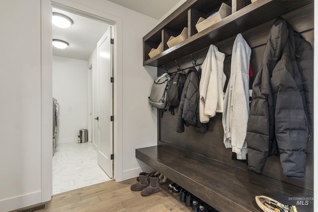 mudroom with wood finished floors, washer / dryer, and baseboards