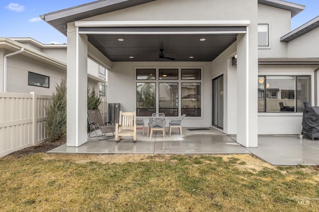 exterior space with a ceiling fan, a patio, fence, a yard, and stucco siding