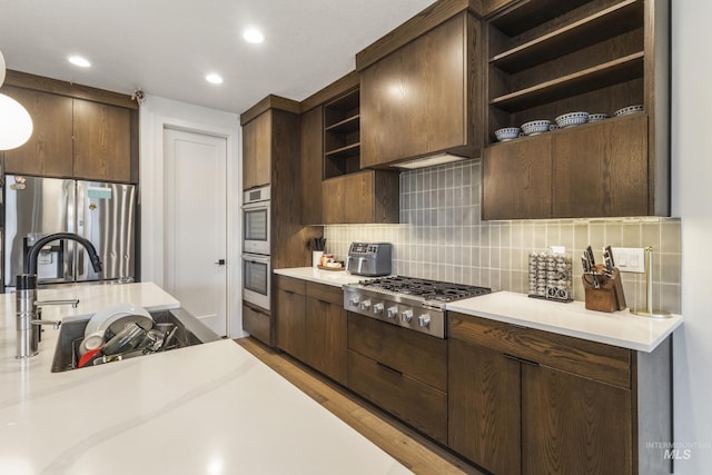 kitchen with open shelves, appliances with stainless steel finishes, light countertops, and dark brown cabinets