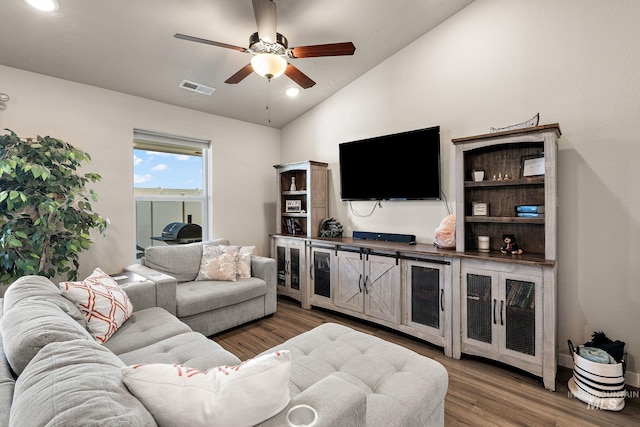 living room with dark hardwood / wood-style flooring, lofted ceiling, and ceiling fan