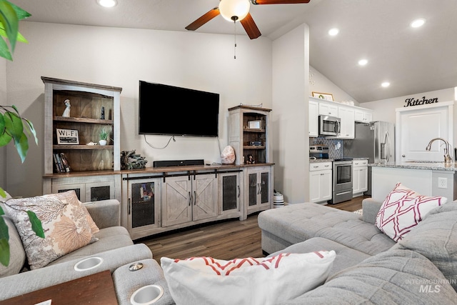 living room with lofted ceiling, sink, dark hardwood / wood-style floors, and ceiling fan