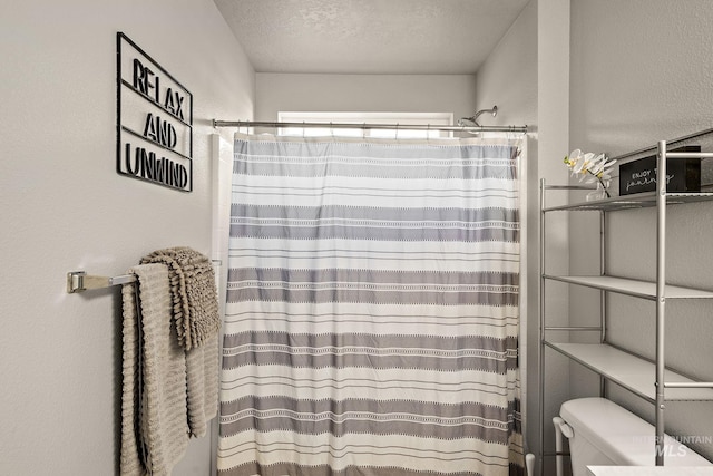 bathroom featuring toilet, a textured ceiling, and walk in shower