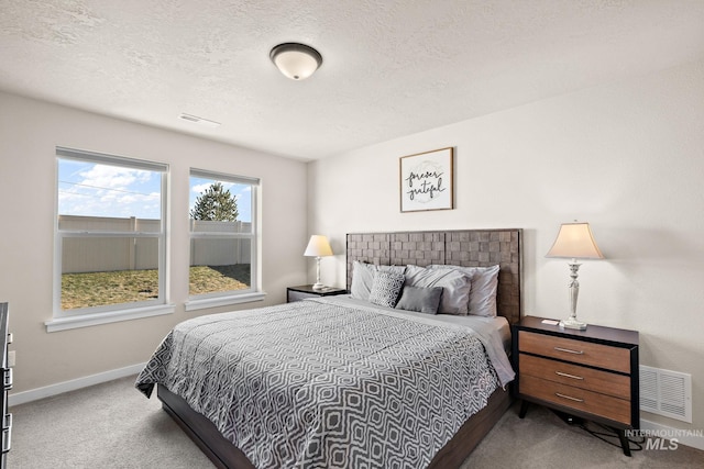 bedroom with carpet floors and a textured ceiling