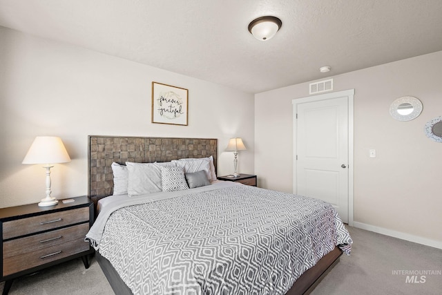 bedroom featuring light colored carpet and a textured ceiling