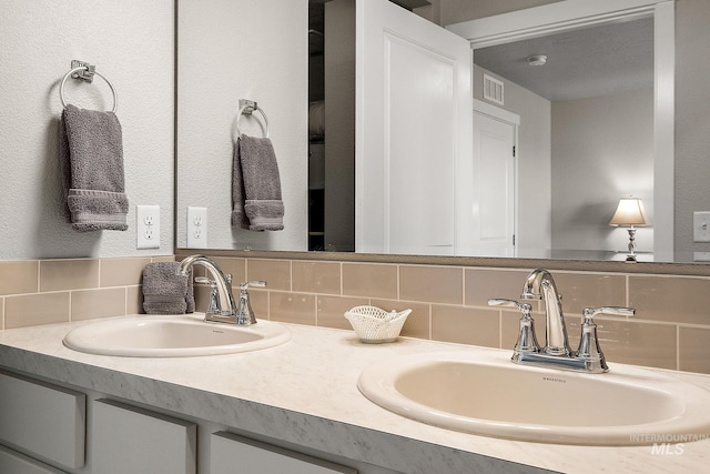 bathroom featuring vanity and backsplash