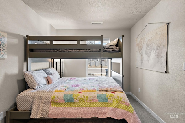 carpeted bedroom featuring a textured ceiling