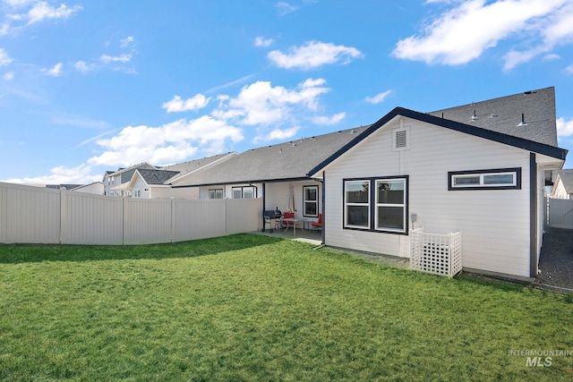 rear view of property with a yard and a patio area