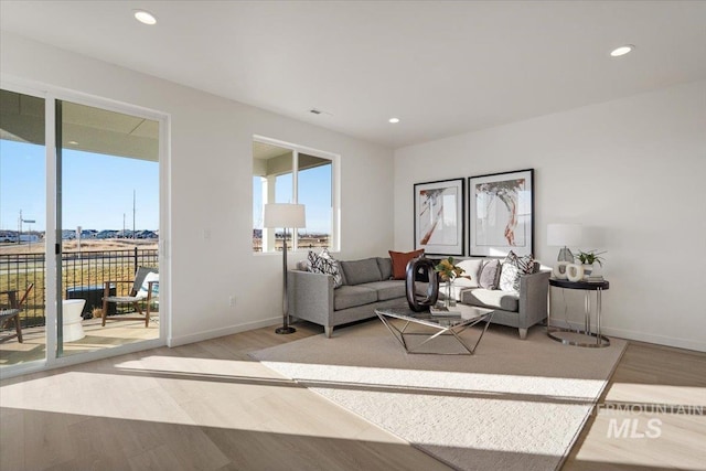 living room featuring recessed lighting, baseboards, and light wood-style floors